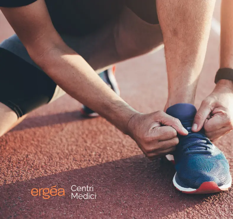 uomo che si allaccia una scarpa